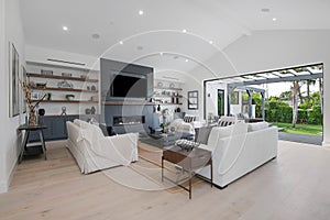 Living room with big screen TV and patio view in a modern new construction home in Los Angeles