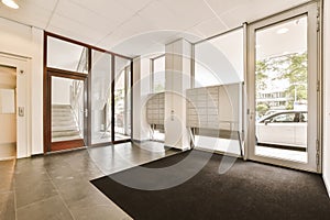 a living room with a black rug and glass doors