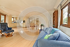 a living room with a blue couch and a kitchen