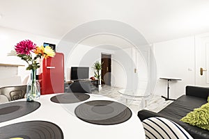 Living room with circular wooden dining table, three-seater black