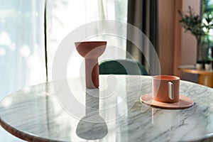 Living room corner decorated with clay ceramic vase and baby pink cup on white marble  table with pink tile stair in the