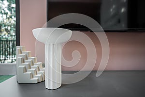 Living room corner decorated with clay ceramic vase and white abstract ceramic vase on gray  table with pink wall in the