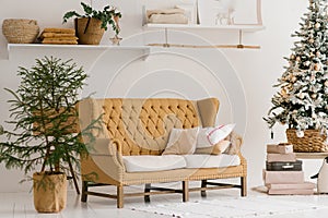 Living room, decorated for Christmas: sofa, Christmas tree with gifts and decorative shelf