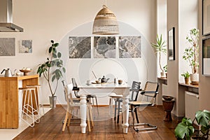 Living room of dining room interior with mock up poster frame, stylish table, rattan chair, wooden kitchen island, white chocker,