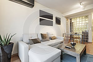 Living room with a gray leather sofa with a divan, a wooden side