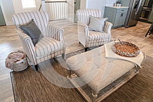 Living room of home with armchairs and table against carpet and wood floor