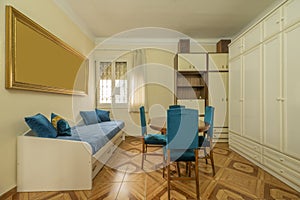 Living room of a house with a wooden dining table with blue upholstered