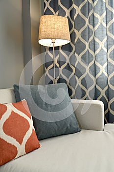 Living room interior fragment with a floor lamp and throw pillows