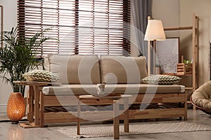 Living room interior with sofa, window blinds and decor elements
