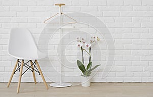 Living room mockup with chair, orchid flowers and clothes rack