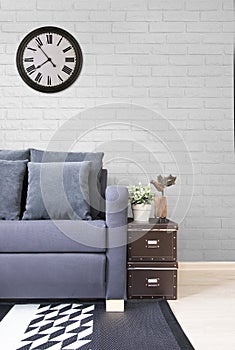 Living room, navy blue satin sofa with boxes and white brick wall. decorate in loft style.