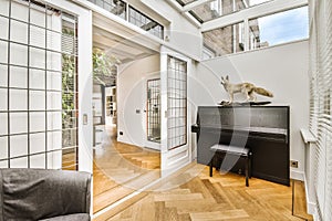 a living room with a piano and a cat statue