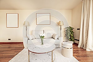 Living room of a vacation rental house with a gold coffee table and gold metal legs, a white sofa and twin lamps