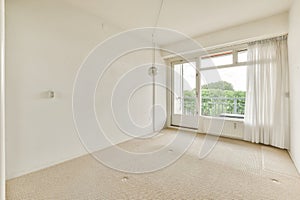 a living room with white walls and a large window