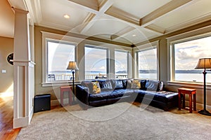 Living room wih many large windows and blue sofa.