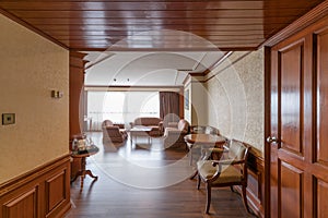 Living room with wooden furnitures of a large suite in a luxury hotel