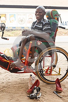 LIVINGSTONE - OCTOBER 14 2013: Local disabled man with an adapted wheelchair sets up successful shoe repair business in