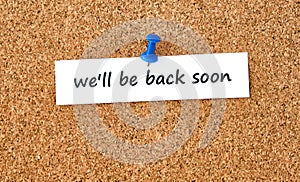 We`ll be back soon. Text written on a piece of paper, cork board background