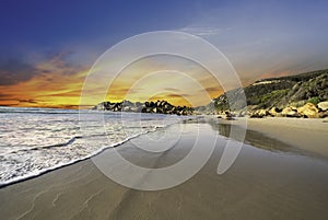 Llandudno sandy Beach at sunset  with rocks and mountain in Cape Town South Africa