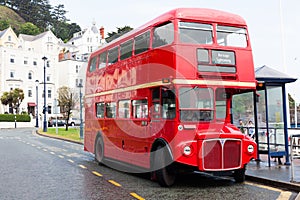 LLandudno, Wales, UK - MAY 27, 2018 Londons red double decker car parked on the road. buses on the stop. Tourism and touristic t