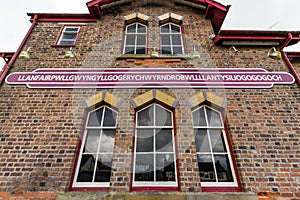 Sign on railway station building for longest name Llanfairpwllgwyngyll, Anglesey, Wales photo