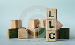 LLC - acronym on wooden cubes on a background of colored block on a light background