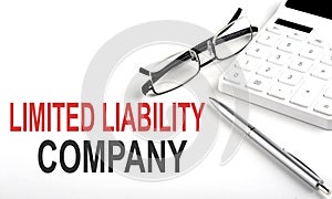 LLC Limited Liability Company Concept. Calculator,pen and glasses on the white background