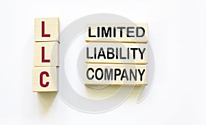 LLC - limited liability company text on wooden blocks on a white background. Finance and economics concept