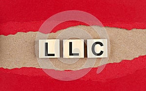LLC word on wooden cubes on red torn paper , financial concept background photo