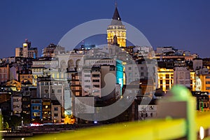 Llighted Galata Tower topping over Beyoglu residential buildings, Istanbul photo