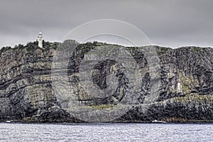 Llighthouse on the cliff at Bull`s Bay, Newfoundland, Canada photo