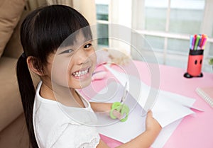 Llittle girl feeling happy doing cutting paper