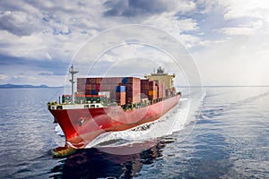 A loaded cargo container ship traveling over blue sea