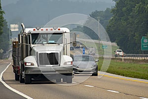 A Loaded Flatbed Eighteen-Wheeler Leads Traffic On A Foggy Day