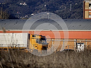 Loaded industrial orange big rig semi truck with long cab for truck driver rest transporting commercial cargo in in dry van semi