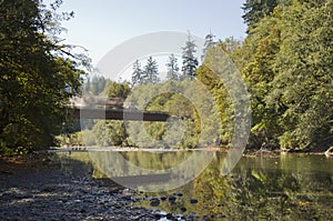 Loaded logging truck speeding across bridge