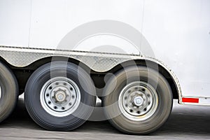 Loaded Semi trailer with three axles transporting cargo running on the road