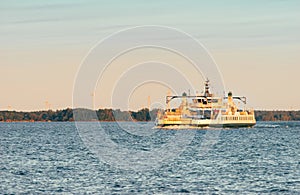 A vehicle ferry crosses open water at sunset