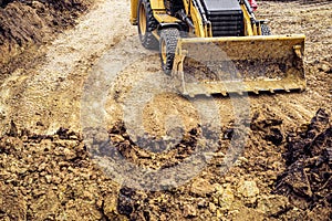 Loader excavator with backhoe for earthmoving works in construction site pit