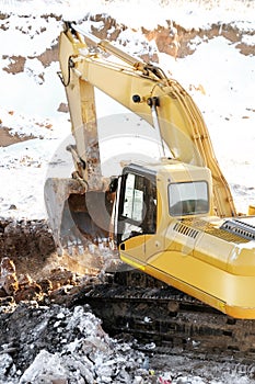 Loader excavator in open cast in winter