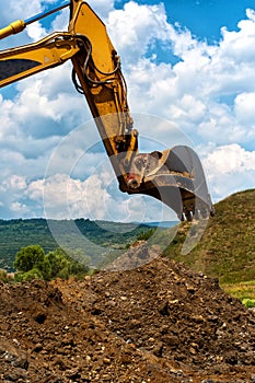 Loader Excavator standing in sandpit with risen bucket