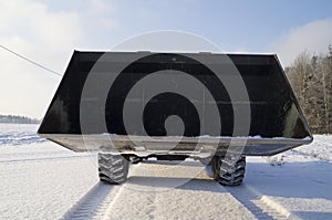 Loader with a huge bucket standing on snowy road