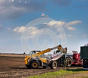 The loader lifts a bag with seeds, sowing