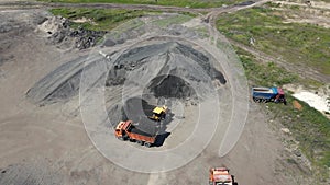 a loader loads crushed stone into a dump truck. aerial shooting