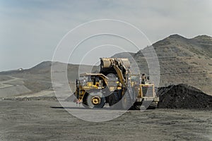 A loader loads ore into a dump truck.