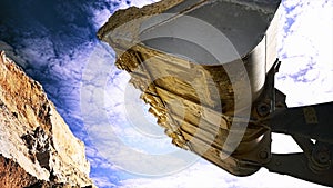 Loader machine unloading sand at eathmoving works at the construction site. Stock footage. Bottom view of the excavator