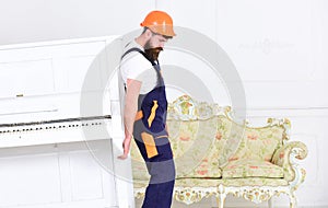 Loader moves piano instrument. Heavy loads concept. Courier delivers furniture, move out, relocation. Man with beard