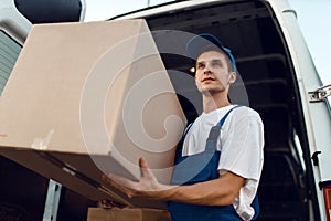 Loader in uniform holding box, delivery service