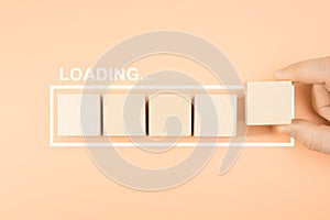 Loading bar with wood cube on pastel background. Wooden blocks with the word LOADING in loading bar progress. Concept loading.
