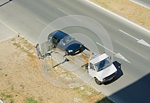 Loading broken car on a tow truck on a roadside